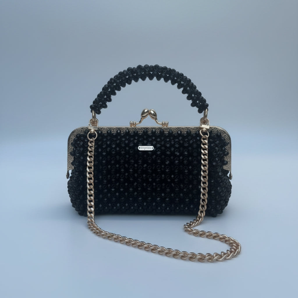 Black beaded handbag with gold chain on a white background