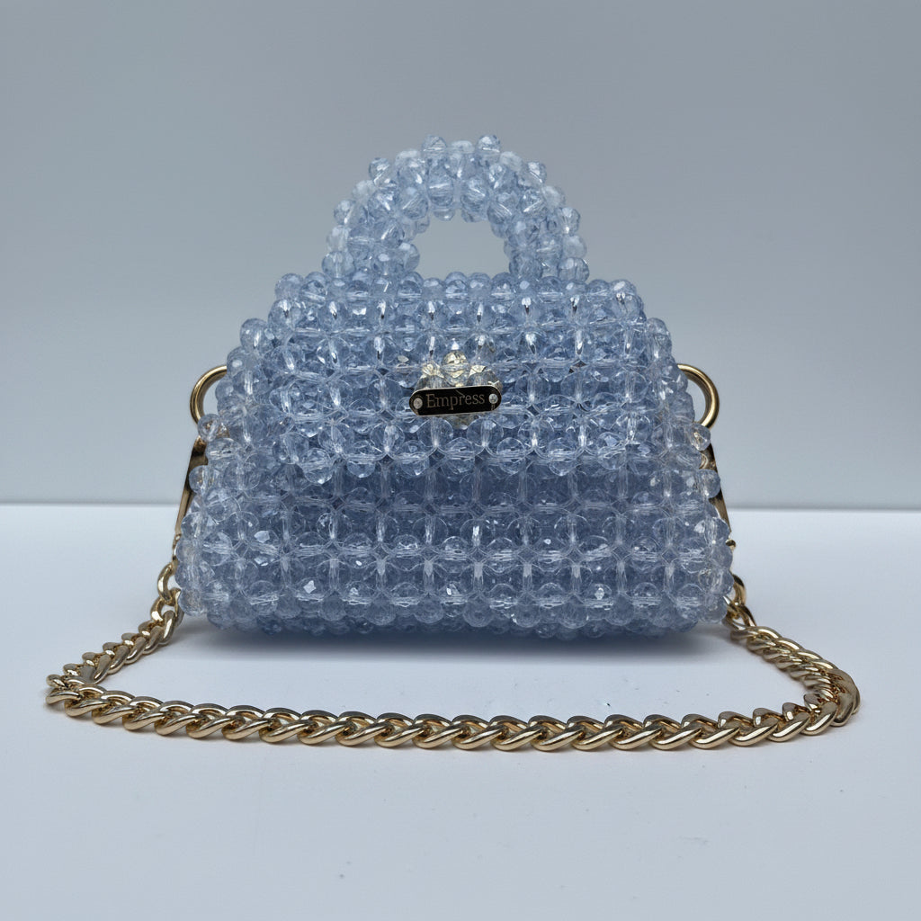 Blue beaded handbag with a gold chain on a white background