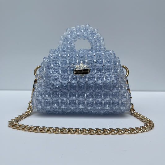 Blue beaded handbag with a gold chain on a white background