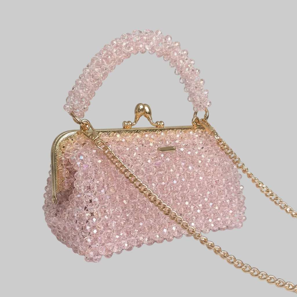 Pink beaded handbag with gold chain on a white surface