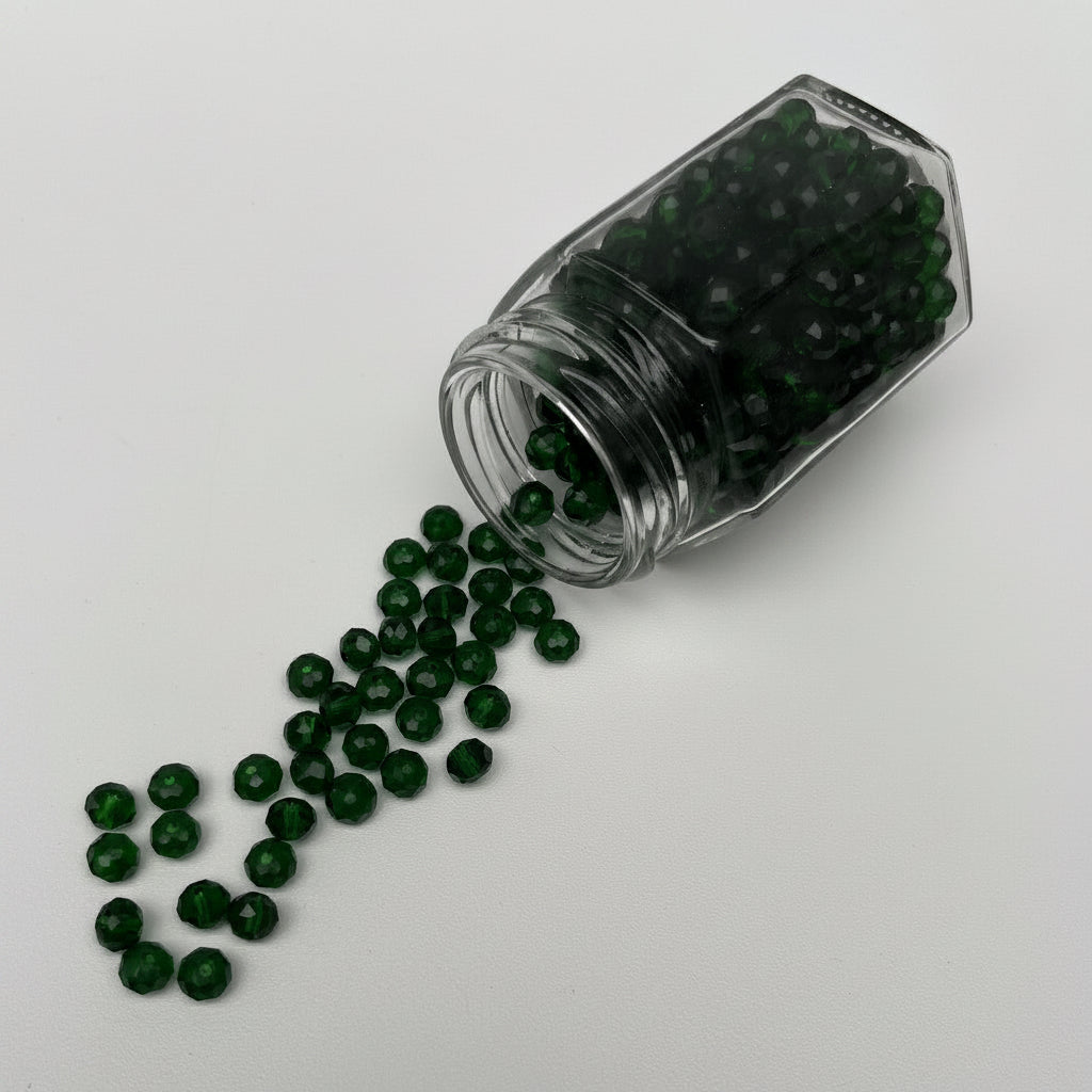 Small glass jar filled with green beads on a white background