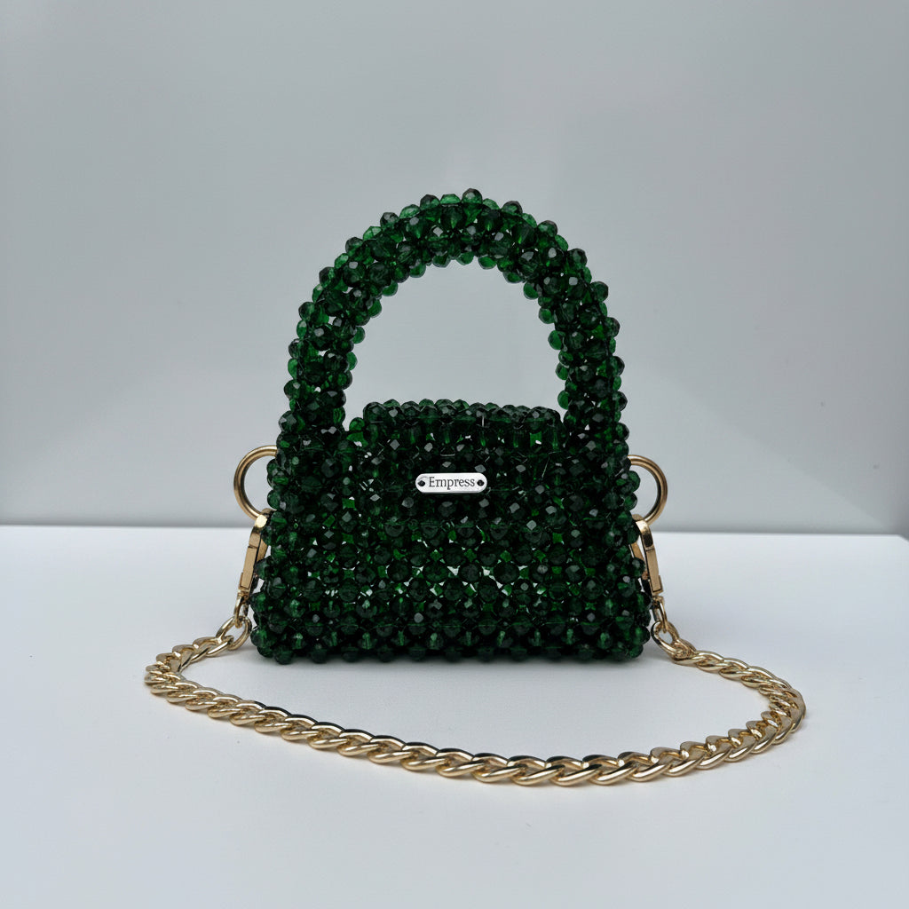 Green beaded bag with gold chain on a white background