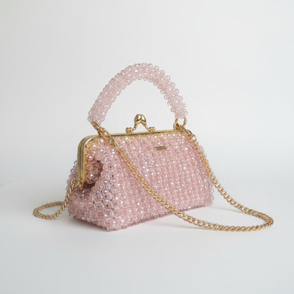 Pink beaded handbag with gold chain on a white surface